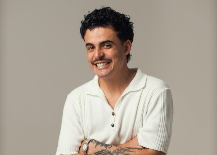 Smiling adult with arms crossed, representing confidence, wellbeing, and adult chiropractic care.
