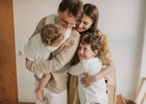 Family with two children embracing closely, representing connection, wellbeing, and family‑focused chiropractic care.