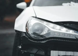 Close‑up of a damaged car front, representing motor vehicle accidents and post‑impact injury recovery.