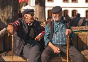 Two older adults sitting together and talking, representing social connection, mobility, and senior chiropractic wellbeing.