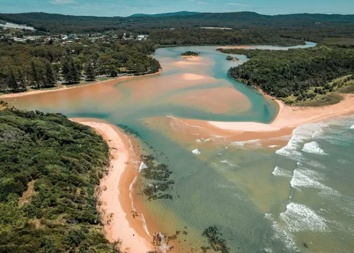 Aerial view of Moonee Beach showing the estuary, sandy shoreline and surrounding coastal landscape.