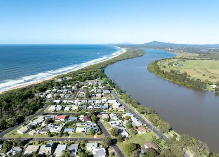 Aerial view of Mylestom showing the river, sandy beach and coastal township.