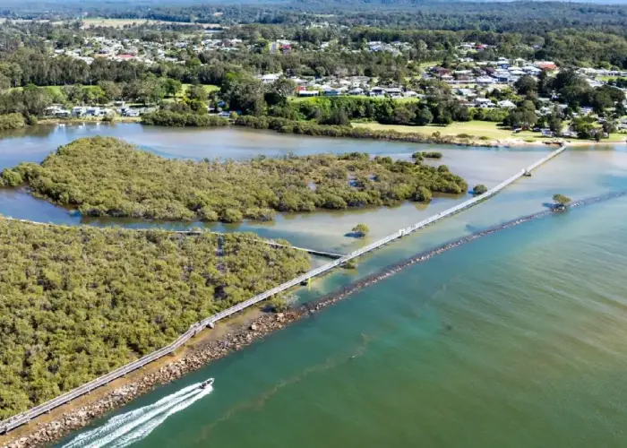 Aerial view of Urunga with boardwalk, estuary and surrounding coastal landscape.
